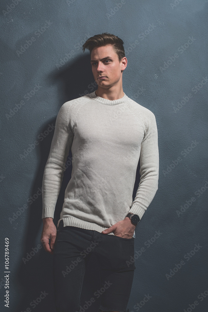 Fashionable casual young man wearing beige sweater and black jea