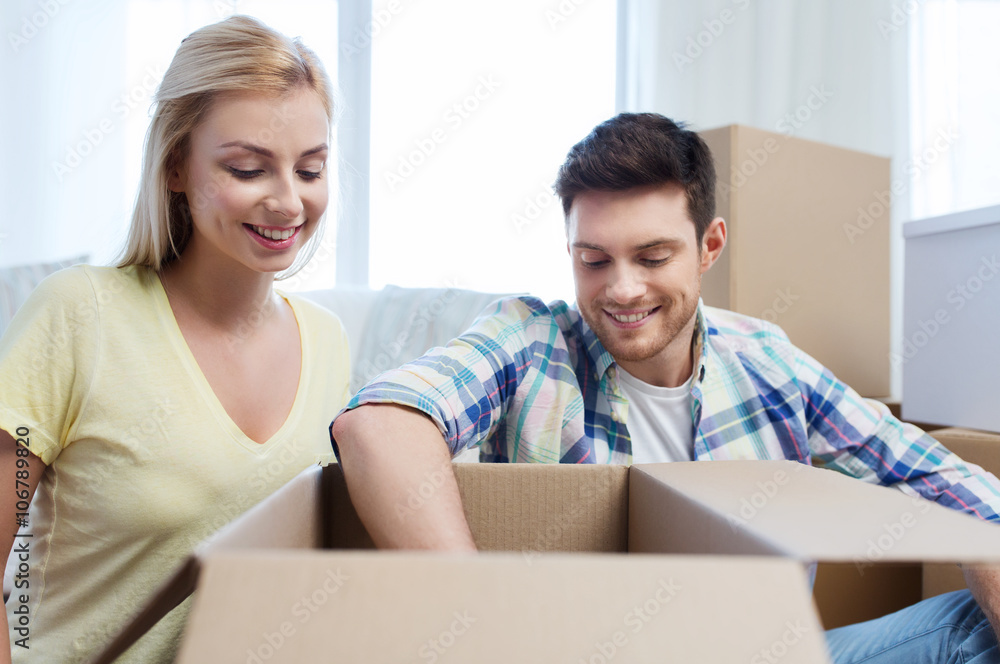 smiling couple with big boxes moving to new home smiling couple with big boxes moving to new home