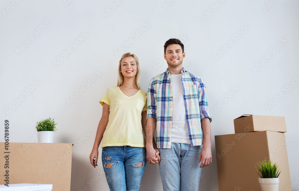 smiling couple with big boxes moving to new home smiling couple with big boxes moving to new home