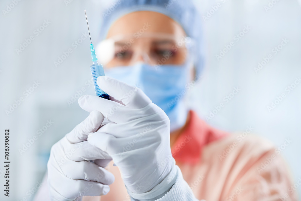 Naklejka premium Female surgeon holding syringe