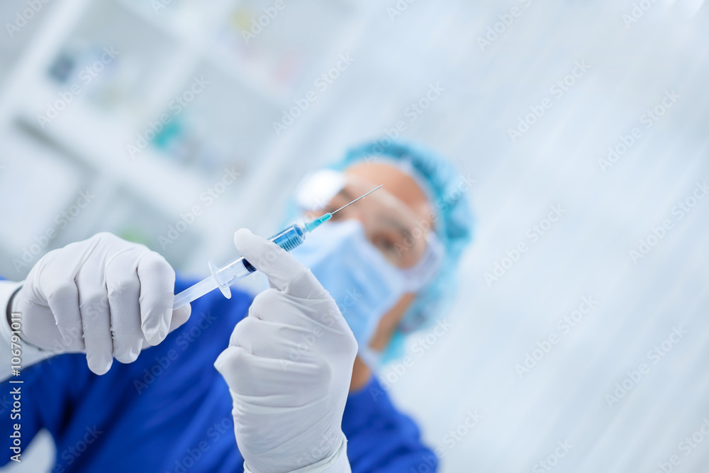 Young surgeon looking at needle Young surgeon looking at needle