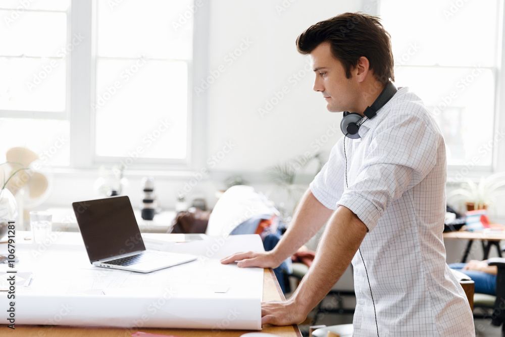 Young man standing in creative office Young man standing in creative office