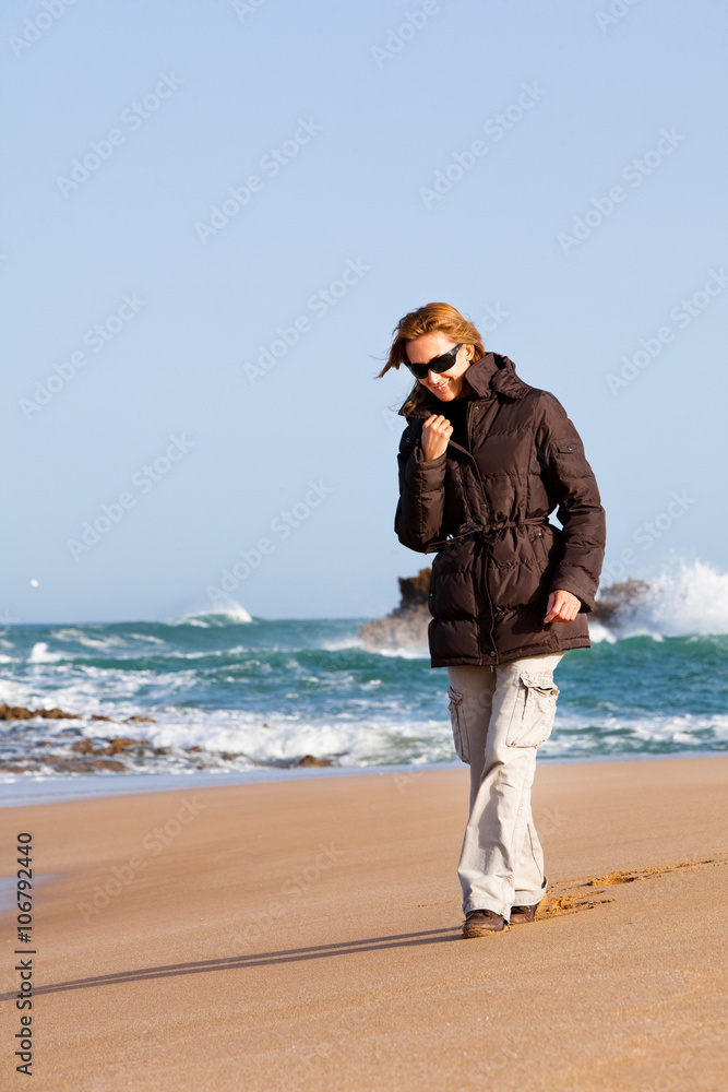 femme qui marche sur la plage en hiver