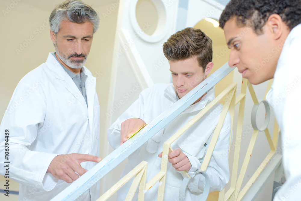 Fototapeta premium Apprentices preparing surface to repaint