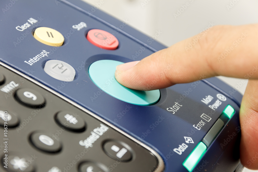 Finger's someone is pushing start copy machine . Finger's someone is pushing start copy machine .