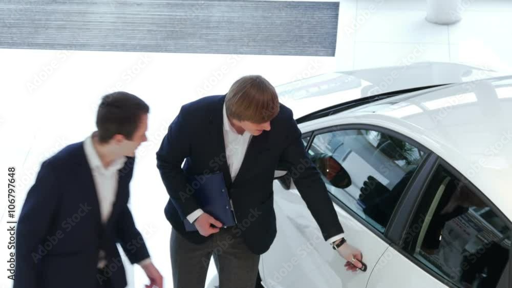 Salesman explains to customer car specifications Salesman explains to customer car specifications