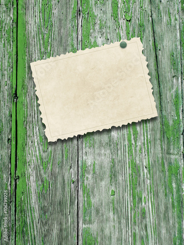 Close-up of one blank brown old vintage postcard frame with pin on grey and green weathered wood background
