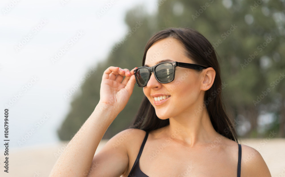 Close up portrait of young beautiful smiling woman on the beach with sea reflection in sunglasses. Focus on sunglasses. Close up portrait of young beautiful smiling woman on the beach with sea reflection in sunglasses. Focus on sunglasses.