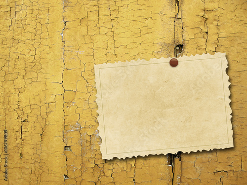 Close-up of one blank brown old vintage postcard frame with pin on ochre weathered wooden boards background