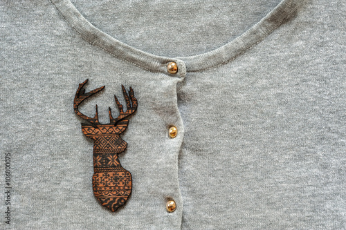 Wooden brown deer on grey pullover photo