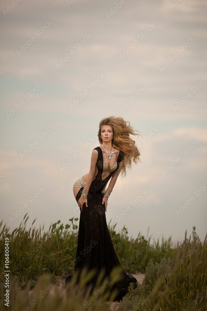 Obraz premium young blond woman in elegant black dress 