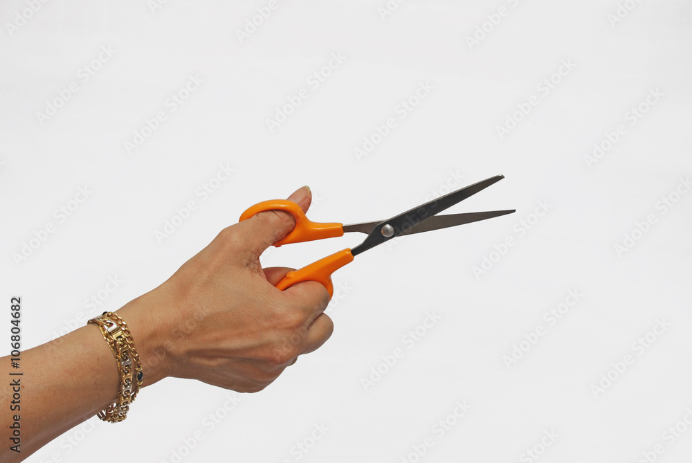 Hand holding orange scissors Hand holding orange scissors