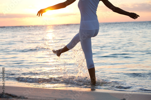 plan serré de jambes de femme éclaboussant dans l'eau le soir