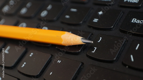 Office scenario, yellow pencil and computer keyboard
