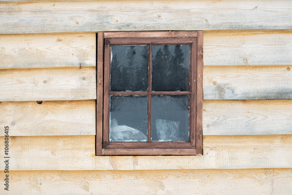 Old wood framed window in a exterior wall of a building with unfinished wood planks Old wood framed window in a exterior wall of a building with unfinished wood planks