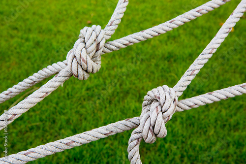 Knot rope netting with a green background.