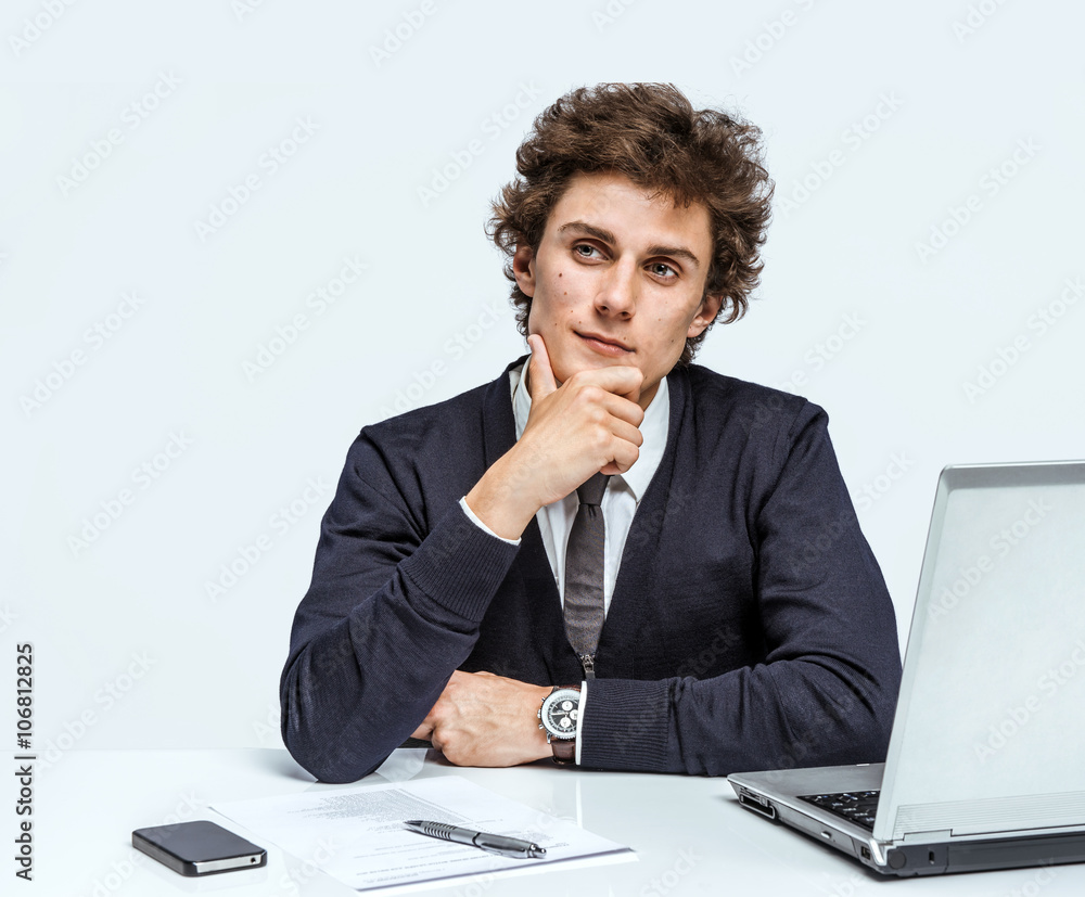 Take thought. Young Businessman at the workplace working with computer on gray background. Take thought. Young Businessman at the workplace working with computer on gray background.