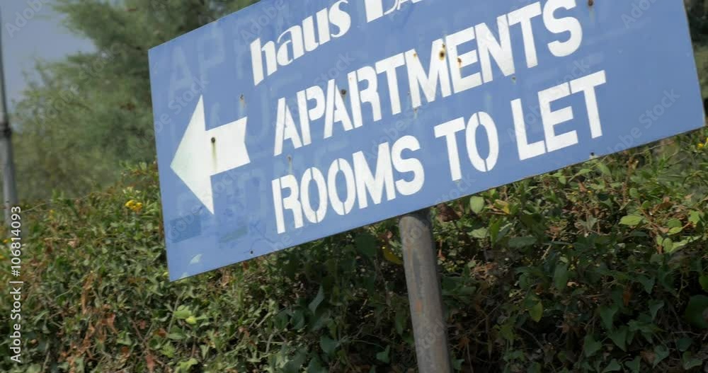 Grungy advertising banner showing the way to apartments and rooms to let with following view to the woman going this direction Grungy advertising banner showing the way to apartments and rooms to let with following view to the woman going this direction