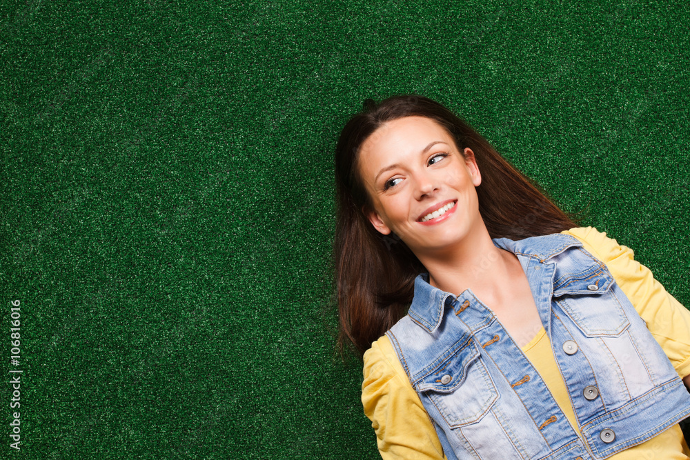 Beautiful young woman enjoys lying on the grass Beautiful young woman enjoys lying on the grass