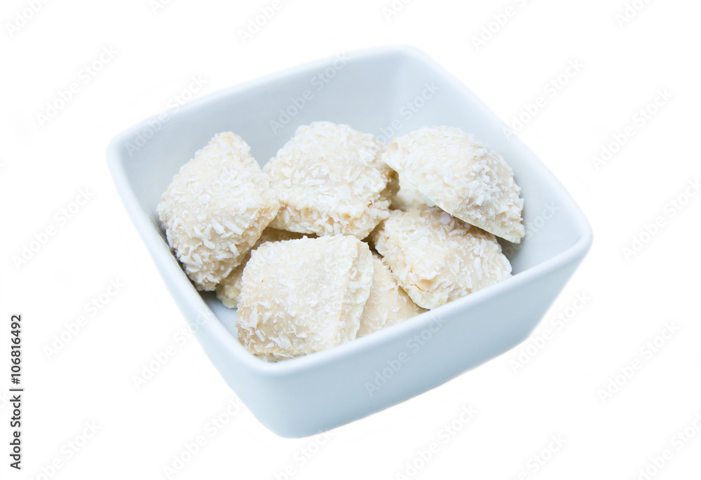 Cakes with coconut on a square bowl on white background