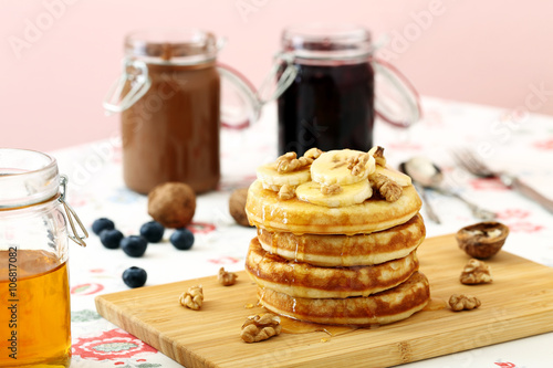 pancake banane noci e miele su tavolo di cucina sfondo rosa