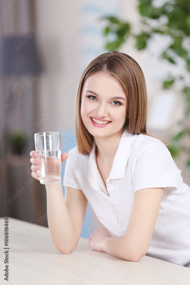 Young woman drinking water from glass in the kitchen Young woman drinking water from glass in the kitchen