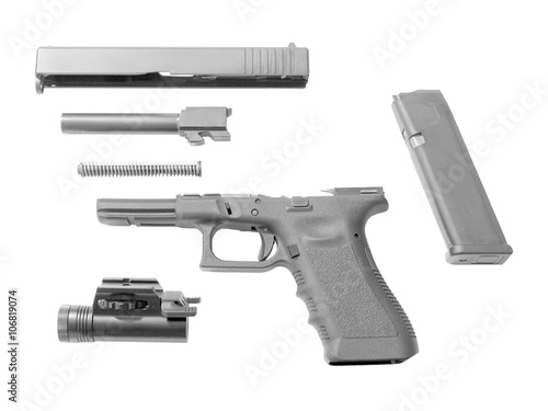 Disassembled handgun isolated on white background. Seperate pistol parts, magazine and torch.
