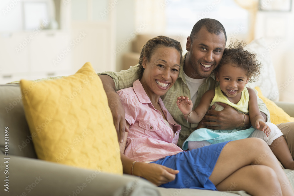 Family smiling on sofa in living room Family smiling on sofa in living room