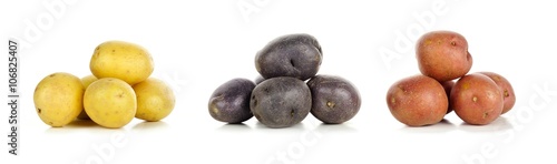 Three piles of yellow, purple and red fresh little potatoes over a white background