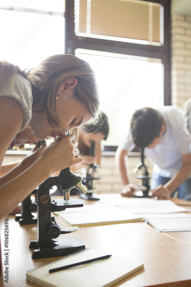 Students using microscopes in science class Students using microscopes in science class