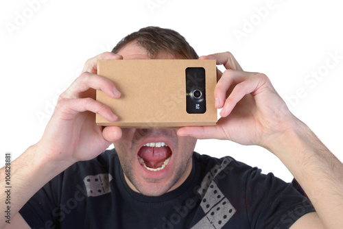 Young man uses virtual reality (VR cardboard) isolated on white background
