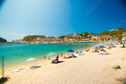 Colorful umbrellas on Puerto de Soller, Port of Mallorca island in balearic islands, Spain. Beautiful picture of people resting on the beach on bright summer day.
