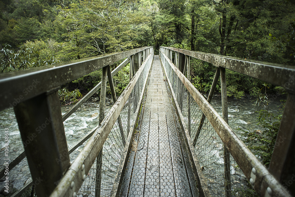 Wooden bridge over river in forest Wooden bridge over river in forest