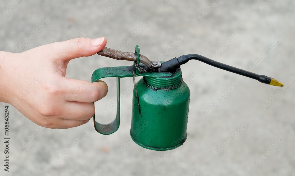 Naklejka premium Hand Holding Old and Dirty Oil Can