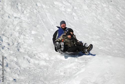 Father and his two sons sledding