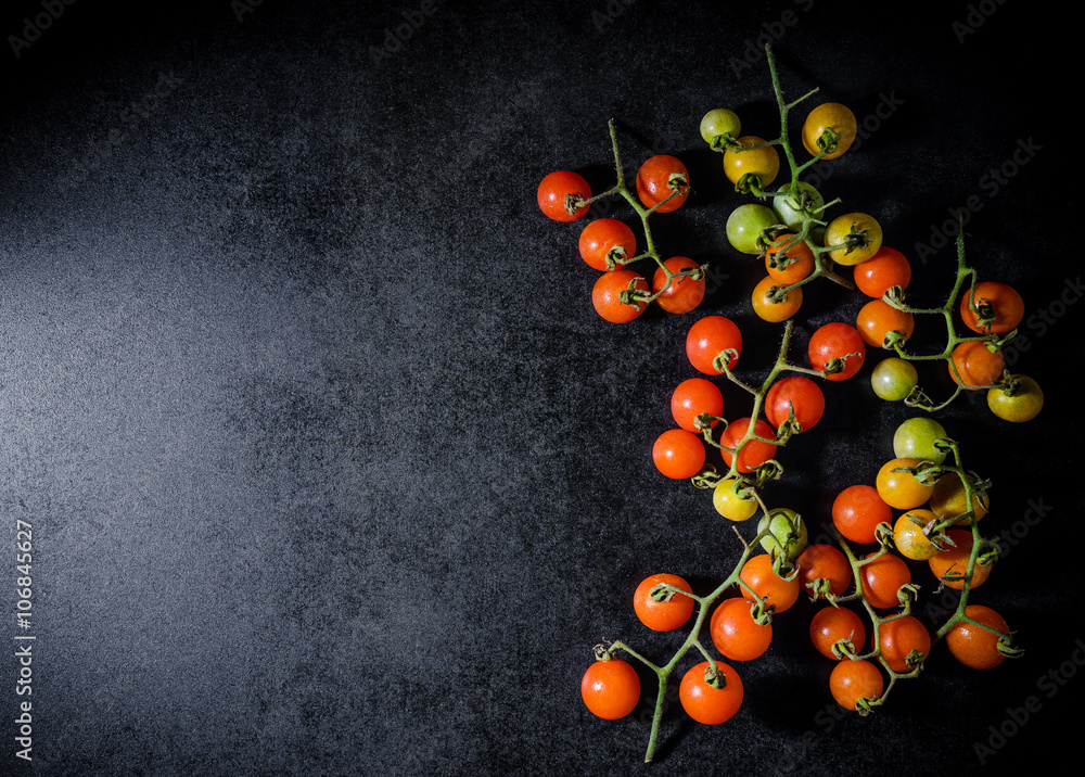 Fresh cherry tomatoes on black wooden background Fresh cherry tomatoes on black wooden background