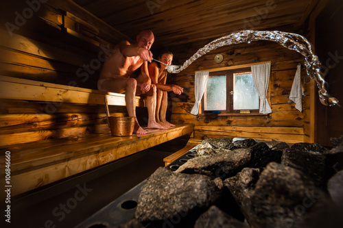 Middle aged couple in traditional wooden Finnish sauna photo