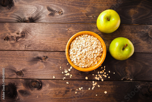 Oat flakes in bowl and two apples
