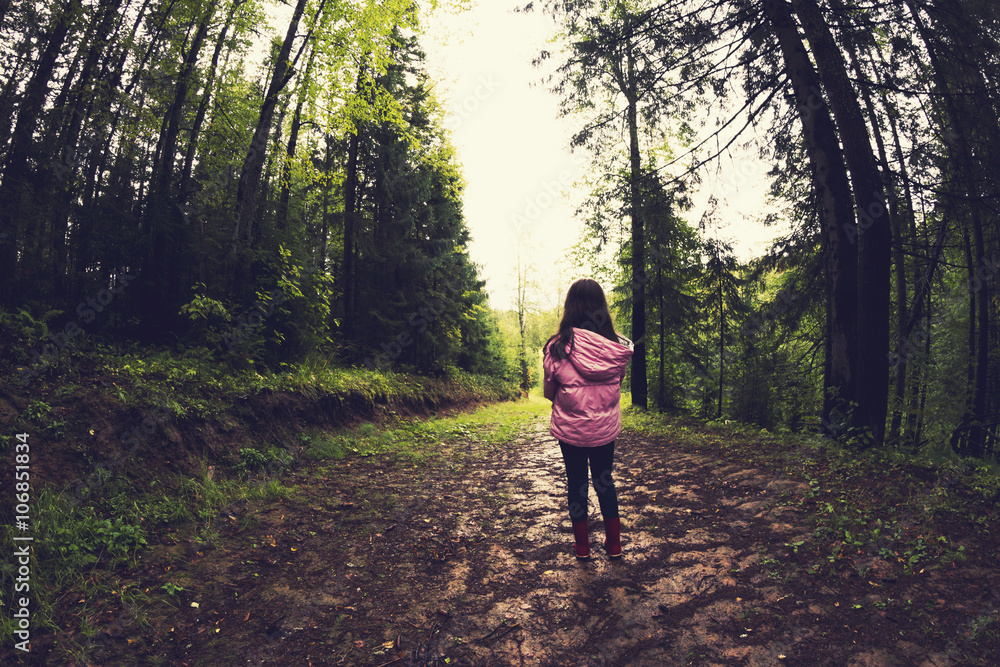 Caucasian girl walking on dirt path in forest Caucasian girl walking on dirt path in forest