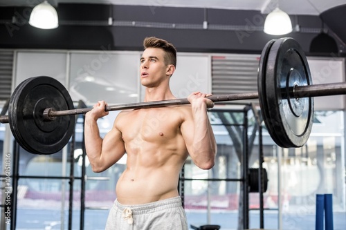 Fit man lifting barbell