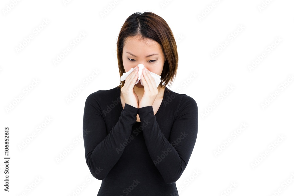 Sick woman blowing her nose with tissue paper Sick woman blowing her nose with tissue paper