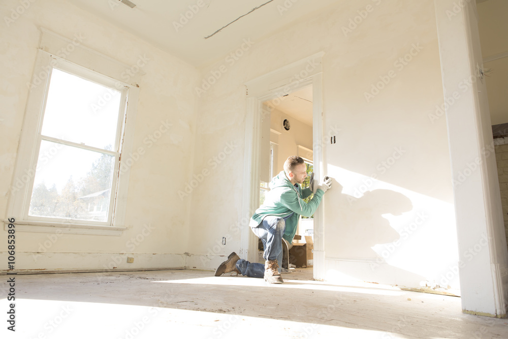Mixed race carpenter working on doorway Mixed race carpenter working on doorway