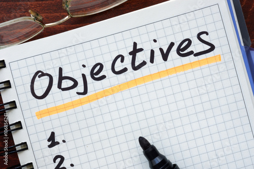 Objectives concept  written in a notebook on a wooden table. photo