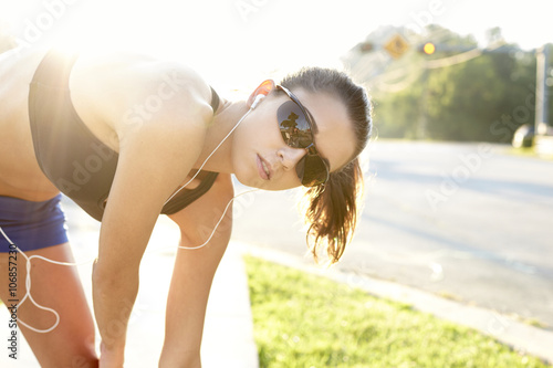 Caucasian runner stretching on sidewalk photo