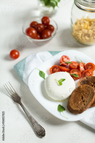 Plate of Caprese Salad with Mozzarella Cheese, Tomatoes, Basil a