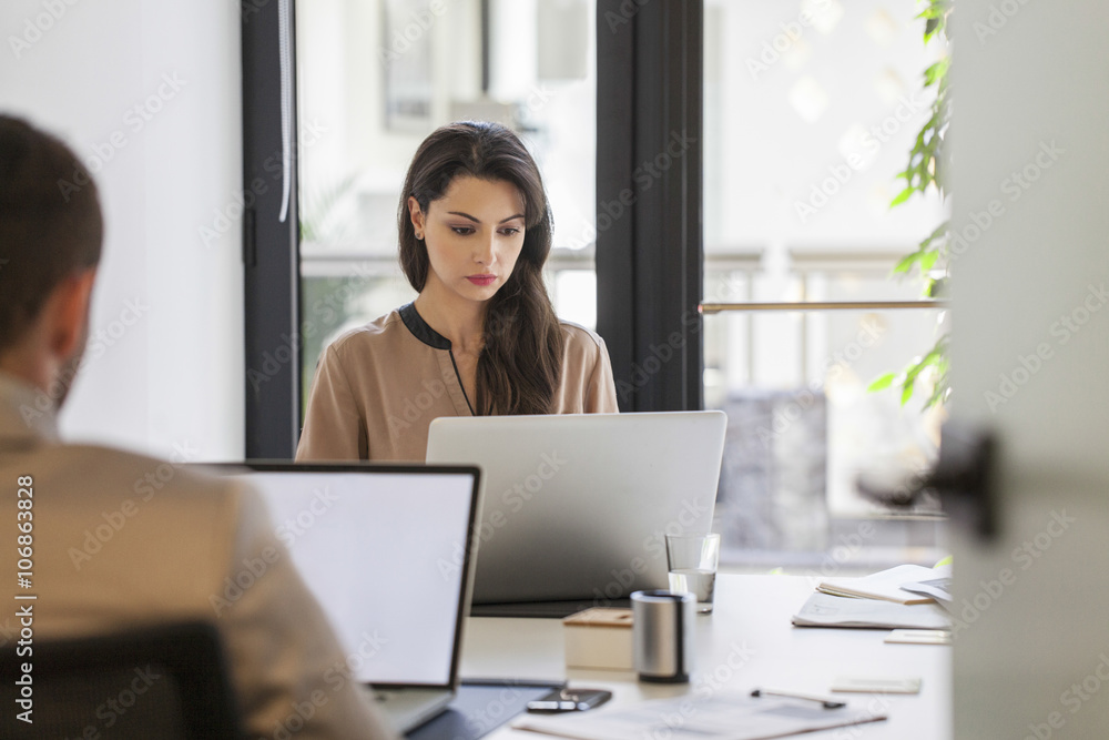 Caucasian business people working at desks in office Caucasian business people working at desks in office
