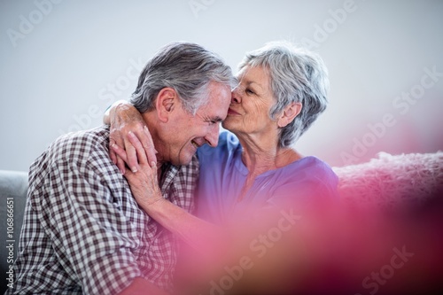 Senior woman embracing and kissing on mans forehead