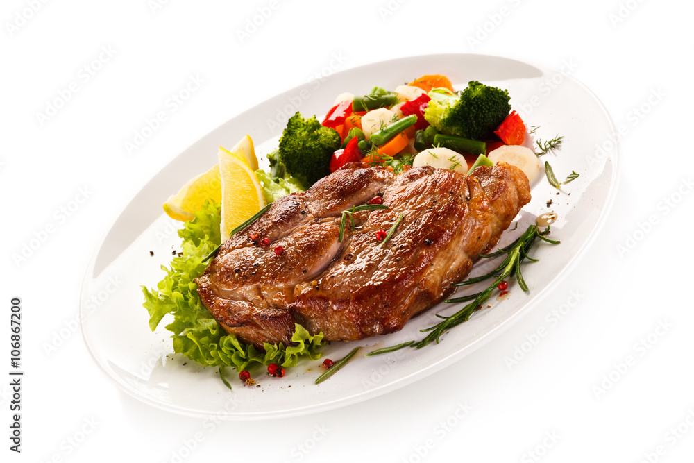 Grilled steak and vegetables on white background