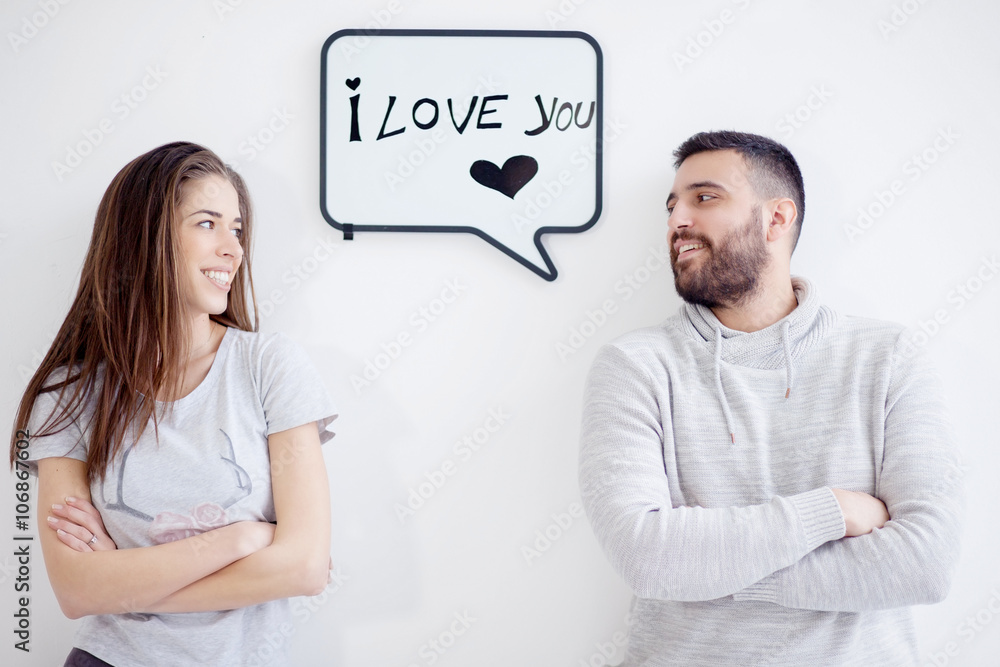 Young couple showing love message written on white board. I love you message. Young couple showing love message written on white board. I love you message.
