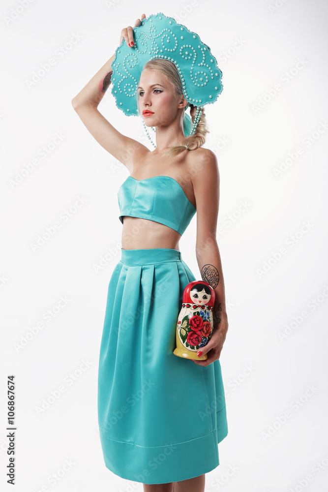 woman with blond hair in russian national hat holding matrioshka doll woman with blond hair in russian national hat holding matrioshka doll